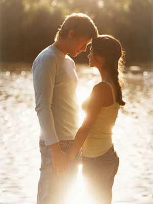 couple holding hands by a lake